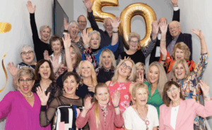 A bunch of women celebrating Nutrimetics 50th birthday with balloons
